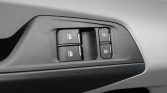 Close-up of a car door panel showing four power window switches and two lock buttons on the right side.