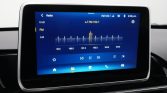In-car touchscreen showing a radio interface with FM 102.1 selected and a frequency bar from 99.5 to 104.5.