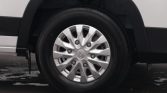 Close-up of a silver alloy wheel and tire on a white vehicle.
