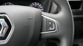 Close-up of a car steering wheel with a chrome-accented control panel showing letters R and O on a black button.