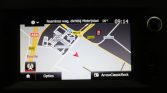 GPS navigation screen showing a map with a red vehicle arrow and surrounding roads; Dutch interface with time 09:14 and 16°C, bottom bar shows 'Opties' and 'ArrowClassicRock'