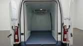Rear doors of a white cargo van open to reveal an empty insulated cargo area with a blue non-slip floor and a ceiling-mounted refrigeration unit at the front.