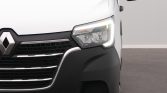 Close-up of the front left of a white Renault van, showing the headlight and grille details.