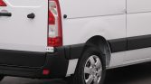White cargo van with a dent on the right rear quarter panel, wheel visible and black bumper below.