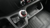 Close-up of a car's six-speed manual gear shift knob with a red ring in a dark interior