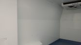 Interior of a refrigerated trailer with white panels, blue non-slip floor, and a Thermo King cooling unit in the ceiling.