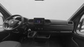 Interior of a van cockpit with steering wheel, central touchscreen display, and manual gear shifter visible from the passenger side door perspective