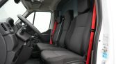 Interior of a white van cab with black fabric front seats and red seat belts visible by the door edge.
