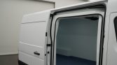 White cargo van with its side door open, showing an empty blue-floored cargo area.