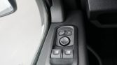 Driver-side door panel with power window switches and a circular mirror adjustment joystick on the armrest.