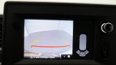 Rear-view camera display with guiding lines (green, yellow, red) for reversing; sensor graphic on the right and Dutch warning text.