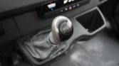 Close-up of a manual gear shift knob inside a car, showing the gear pattern on the top surface.