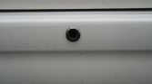 Backup camera embedded in a white car bumper (rear view)