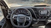 Interior view of an Iveco van cockpit—steering wheel, instrument cluster, gear shifter, and navigation screen on the center console