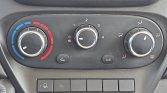 Car climate control panel with left blue-to-red temperature dial, middle fan speed dial, and right airflow direction dial including defog button and A/C button.