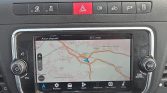 Car navigation screen showing a map with a blue car icon on the route and surrounding towns.