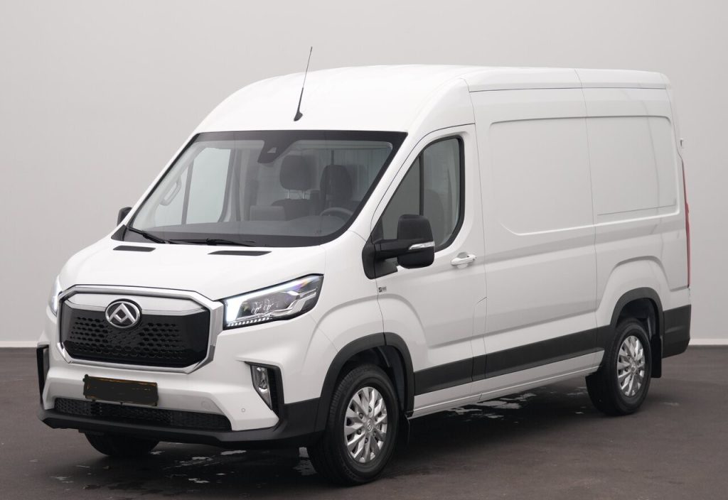 White cargo van in a three-quarter front view, parked indoors, showing its high roof and side panels like a delivery vehicle.