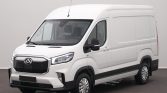 White cargo van in a three-quarter front view, parked indoors, showing its high roof and side panels like a delivery vehicle.