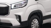 Front left corner of a white van, showing the headlight, grille, and front wheel.