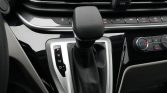 Automatic gear shift lever in center console with P R N D indicators visible and surrounding car interior features nearby