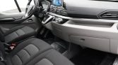Interior view of a modern car: driver and passenger seats, steering wheel, and a central touchscreen display on the dashboard.