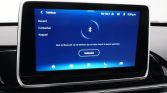 In-car touchscreen showing Bluetooth pairing screen with Dutch text and a prominent 'Verbind' button, backdrop of blue UI.