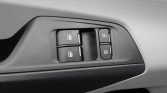 Car door interior panel with four power window switches and two lock buttons, shown in a close-up.