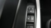 Car door control panel with four window switches and a window lock button, close-up.