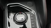 Circular EV gear selector with R N D indicators on a glossy black center console, surrounded by a chrome ring and red accent light at top; to the right are vertical mode buttons (OFF, ECO, PWR).