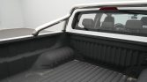 Pickup truck bed with a chrome roll bar and a ribbed black bed liner.