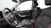 Interior view of a modern car showing the steering wheel, front seats with red stitching, and center console.