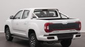 Rear-left view of a white pickup with a tubular roll bar in the bed and MAXUS on the tailgate.
