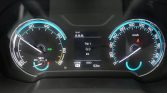 Car dashboard instrument cluster: left tachometer with green 'READY' indicator, center trip/odometer screen, right speedometer up to 180 km/h, with a yellow/blue accent ring and warning icon visible in the center.