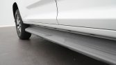 White SUV with a running board along the bottom edge of the passenger side.