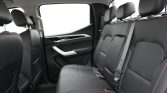 Black leather rear seat with red contrast stitching and three seat belts in a modern car interior.