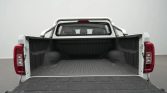 Empty white pickup truck bed with tailgate down, showing a ribbed cargo floor and rear lights on both sides