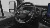 Interior of a Ford vehicle: steering wheel with Ford logo, dashboard gauges, and a right-side touchscreen visible in the background.