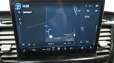 Car infotainment touchscreen displaying a map navigation view with a blue route and street names (Meierijstad) on the center console tablet in a car interior.