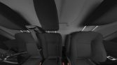 Interior of a car showing front seats with headrests, seat belts, and a partial view of the steering wheel on the left.