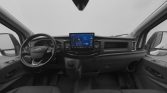 Interior view of a modern van cockpit showing steering wheel, central touchscreen display, and dashboard controls from the driver's seat.