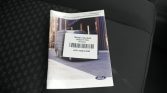 Ford Transit brochure on a dark car seat with a white barcode label covering the middle of the cover