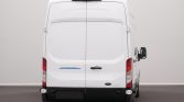 Rear view of a white Ford Transit cargo van in a neutral studio setting, showing rear doors and view of taillights.
