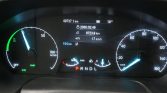 Car instrument cluster: speedometer on the right, tachometer on the left, central digital screen with trip and mileage data and gear indicator below.