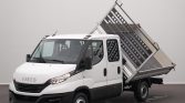 White Iveco utility truck with a tilted metal dump bed raised to the side, parked on a gray lot.