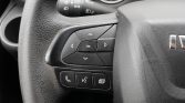 Steering wheel controls with a directional pad and center OK button; below are phone and voice command icons on a textured black steering wheel panel
