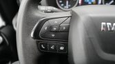 Close-up of the left side of a car steering wheel showing a directional pad and an OK button, plus phone and menu controls beneath