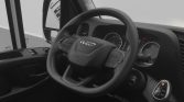 Inside view of a truck cab featuring a round steering wheel with the IVECO logo, instrument cluster, and gear selector visible on the right side