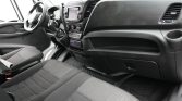 Front interior of a van showing the steering wheel, center touchscreen, and climate controls above a rubber floor mat.