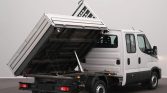 White delivery truck with a raised tipping bed supported by a hydraulic cylinder, viewed from the rear side in a studio setting