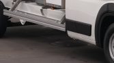 White utility truck with a lowered side lift ramp extending from the cargo area.